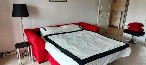 - une chambre avec un lit rouge et une chaise rouge dans l'établissement Appartement lumineux à Beausoleil (proche Monaco), à Beausoleil