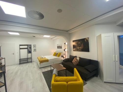 a living room with a couch and a bed at Chice, urbane Oase mit Arbeitsplatz in Troisdorf