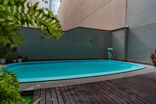 uma grande piscina azul ao lado de um edifício em HANNA Balneário Hotel em Balneário Camboriú