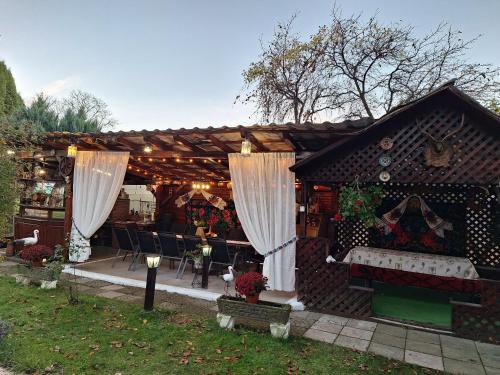 een peperkoekhuis met witte gordijnen in een tuin bij PENSIUNEA ROMINVEST in Borşa