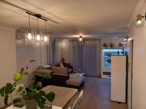 ein Wohnzimmer mit einem Sofa und einem Tisch in der Unterkunft Maison calme/Chambre privée/Clim+TV/Pétit dejeuner inclu/tout confort in Nevers