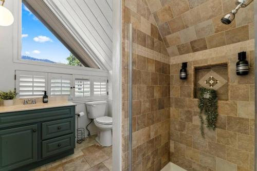 La salle de bains est pourvue d'une douche, de toilettes et d'une fenêtre. dans l'établissement Peaceful North Fork Cabin w/ Fireplace & Wi-Fi!, à North Fork