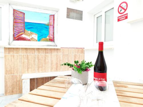 a bottle of wine sitting on top of a table at Bonito estudio con patio interior en Altea in Altea