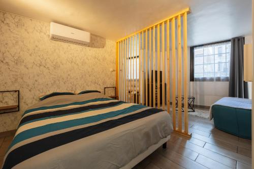 une chambre avec un lit et une grande fenêtre dans l'établissement Coin De Paradis au Coeur de Martigues RDC Wifi, à Martigues