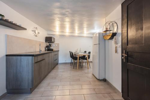 une cuisine avec une table et un réfrigérateur blanc dans l'établissement Coin De Paradis au Coeur de Martigues RDC Wifi, à Martigues