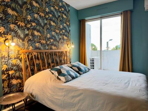 een slaapkamer met een bed en een groot raam bij Maison au calme 2 Chambres Terrasse Clim parking gratuit in Montpellier