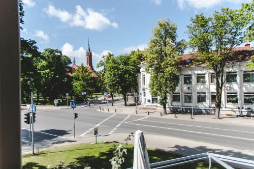 an empty street with a white building and a church at The House in Druskininkai