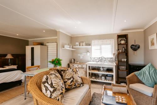ein Wohnzimmer mit einem Sofa und einem Tisch in der Unterkunft Dennehof Farm Guesthouse in Villiersdorp
