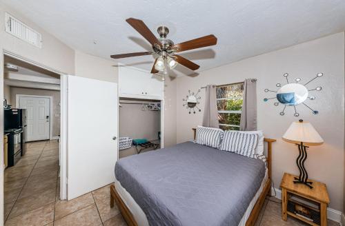 1 dormitorio con 1 cama y ventilador de techo en Tropical Blue Water beachside 7 en Clearwater Beach