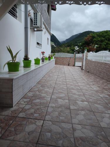 a patio with potted plants on a building at Villa bébélos in Pointe-Noire