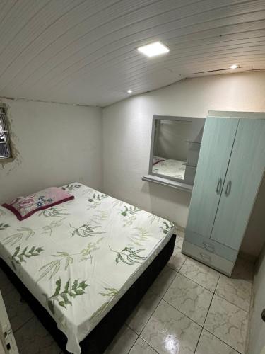 - une chambre avec un lit et une armoire dans l'établissement Casa baixinha, à Ubajara