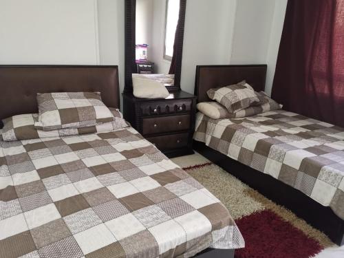 two beds sitting next to each other in a bedroom at Heliopolis Roxy in Cairo