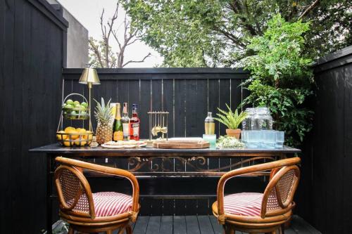 a bar on a black fence with two chairs at Mr. Nomad: Artistic Abode in Uptown in Dallas