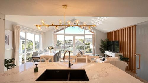 a kitchen and living room with a large window at Stunning Rothesay Bay in Auckland