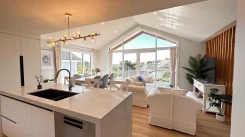 a kitchen and living room with a large window at Stunning Rothesay Bay in Auckland