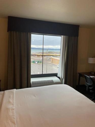 a hotel room with a bed and a large window at Cobblestone Inn and Suites - Ashland in Ashland