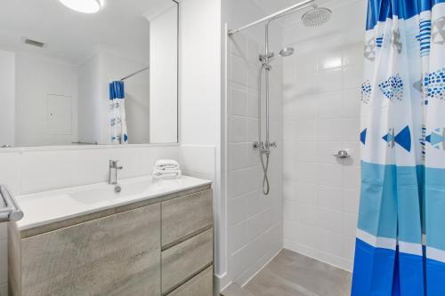 a bathroom with a shower and a sink at Kings Bay Apartments in Caloundra