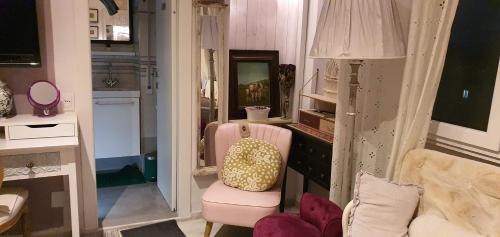a living room with a pink chair and a mirror at Suite in House.. in Florence