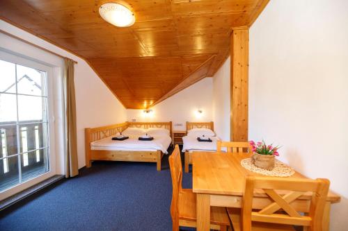 a room with two beds and a table and a window at Pension Big Apple in Železná Ruda