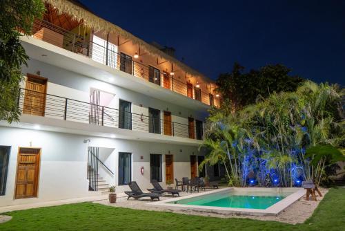 a hotel with a swimming pool in front of a building at Hotel Makech in Bacalar