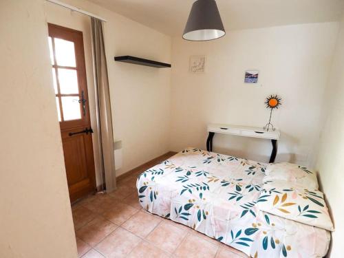 une petite chambre avec un lit et un bureau dans l'établissement gîte mas d'en pachette, au Boulou