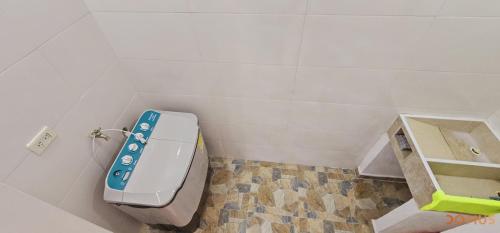 a bathroom with a toilet with a blue remote control at Rooftop Cerca al Rio Guatapuri Vista Panoramica in Valledupar
