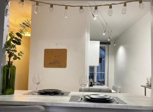 une cuisine avec une table avec deux verres et un vase dans l'établissement Charme Historique de Beauvoir au Cœur de Blois, à Blois