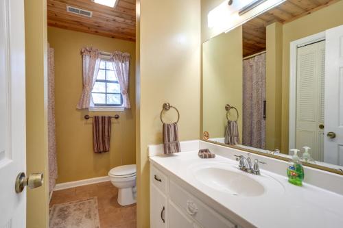 een badkamer met een wastafel, een toilet en een spiegel bij Quaint Chattanooga Valley Retreat Private Hot Tub in Fort Oglethorpe