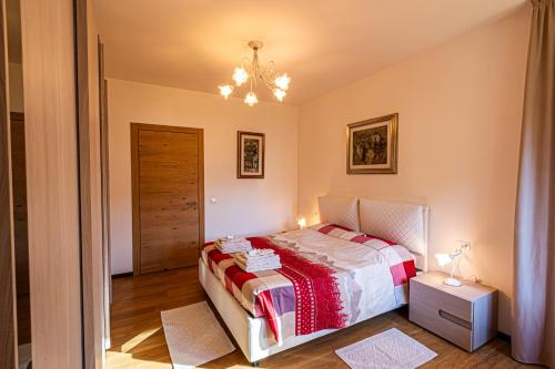 ein kleines Schlafzimmer mit einem Bett und einem Kronleuchter in der Unterkunft Villa Marmarole a Calalzo in Calalzo