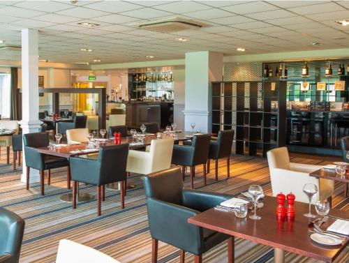 a restaurant with tables and chairs and a bar at Sunningdale Lodge,St Mellion,Cornwall-FreeGolf&Spa in St. Mellion