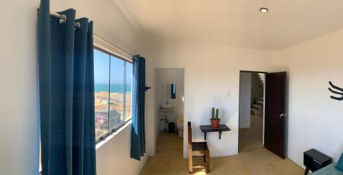 a room with a window with a view of the ocean at Tayta Surf House in Lobitos