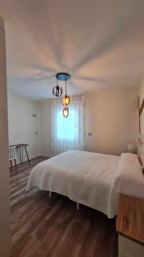 ein Schlafzimmer mit einem großen weißen Bett und einem Fenster in der Unterkunft La Avenida in Burgos