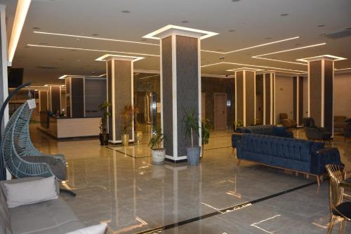 a lobby with blue benches and chairs in a building at MyFlower 3 Hotel in Erbil