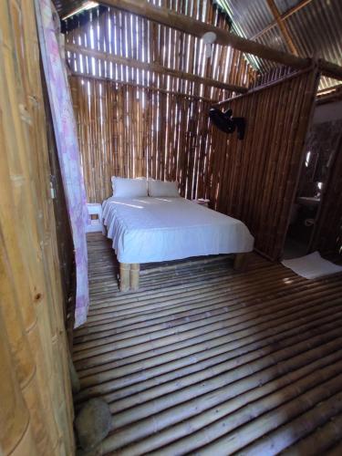 a bed in a room with a wooden floor at Balneario el paraíso in Puerto Triunfo