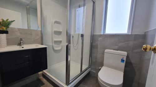 a bathroom with a shower and a toilet and a sink at Mt Eden 2 Beddie home in Auckland
