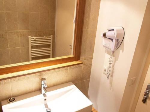 La salle de bains est pourvue d'un lavabo avec miroir et d'un sèche-cheveux. dans l'établissement Centre station, Garage et Local à ski, à Isola 2000
