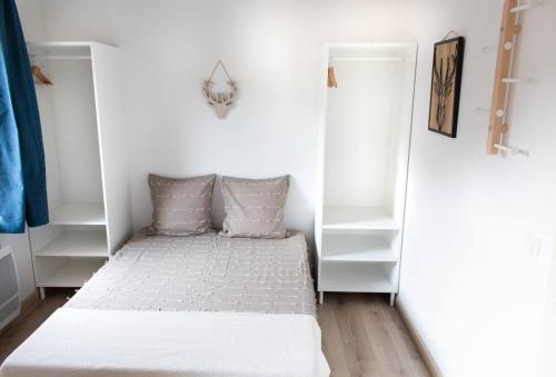 Cette petite chambre comprend un lit et des étagères blanches. dans l'établissement Centre station, Garage et Local à ski, à Isola 2000