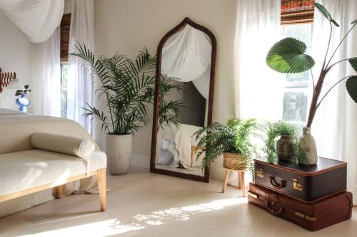 ein Schlafzimmer mit einem Spiegel, einem Bett und Pflanzen in der Unterkunft Mr. Nomad: Casa Bohem in Uptown in Dallas