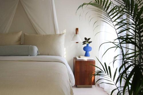 ein Schlafzimmer mit einem Bett und einer Topfpflanze in der Unterkunft Mr. Nomad: Casa Bohem in Uptown in Dallas