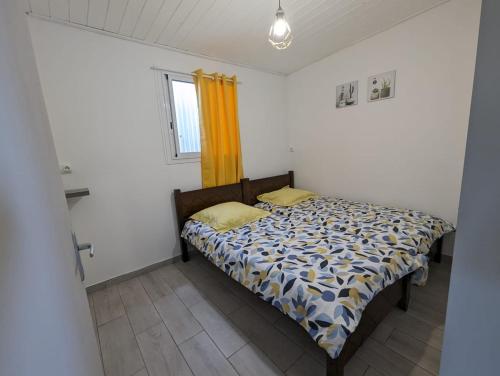 - une chambre avec un lit et un rideau jaune dans l'établissement Ti Kaz Galet, à La Possession