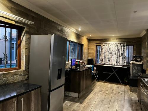 a kitchen with a refrigerator and a desk at Phindulo Bed and Breakfast - No Loadshedding, Smart TVs & unlimited free fibre wifi in Krugersdorp
