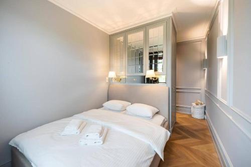 een kleine slaapkamer met een wit bed met 2 kussens bij Luxury Garden Apartment in Warschau