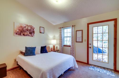 1 dormitorio con cama blanca y almohadas azules en Burnside Resort Cabin with Hot Tub and Outdoor Spots!, en Burnside