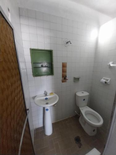 a small bathroom with a toilet and a sink at Hotel Guaipa in Melgar