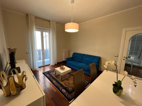 een woonkamer met een blauwe bank en een tafel bij [Centro] Lussuoso Appartamento in Bergamo