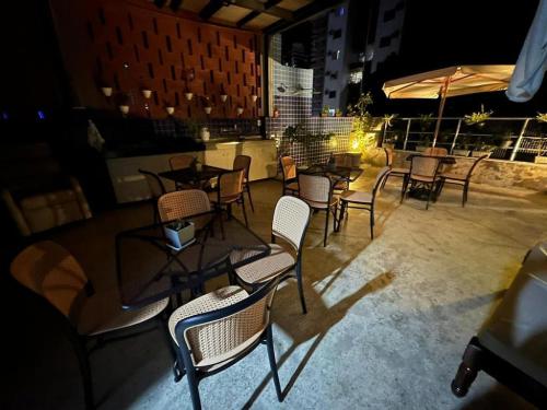 a group of chairs and tables on a patio at night at STUDIO 303 | WIFI 600MB | RESIDENCIAL JC, um lugar para ficar. in Belém