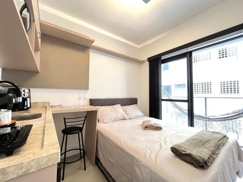 a bedroom with a bed and a kitchen with a counter at Start - Vila Izabel in Curitiba