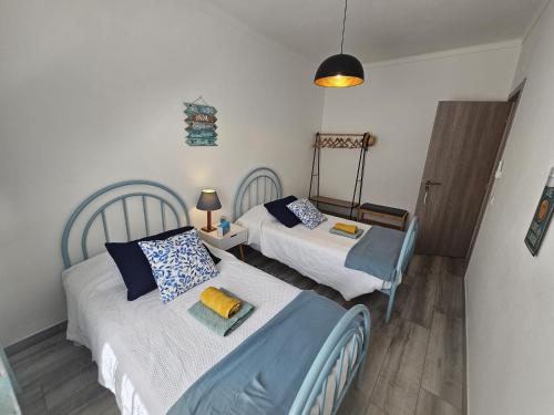 a bedroom with two beds and a chair in it at Catita Home in Vila Nova de Cacela