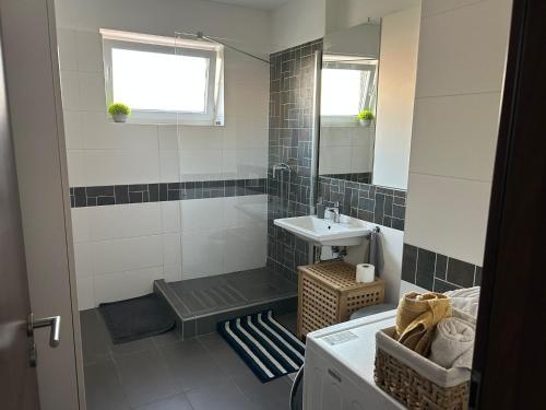 a bathroom with a shower and a sink and a tub at Apartmán "DUNAJ" private parking - klimatizácia in Šamorín