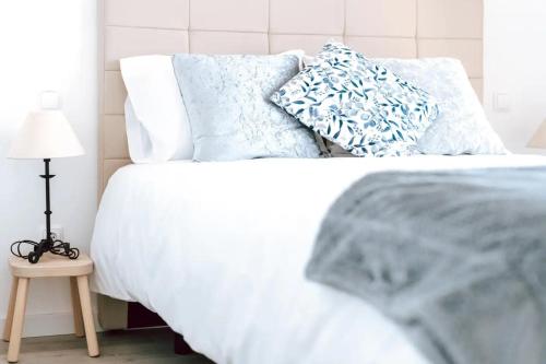 Una cama blanca con almohadas azules encima. en Sea View Baleal en Peniche